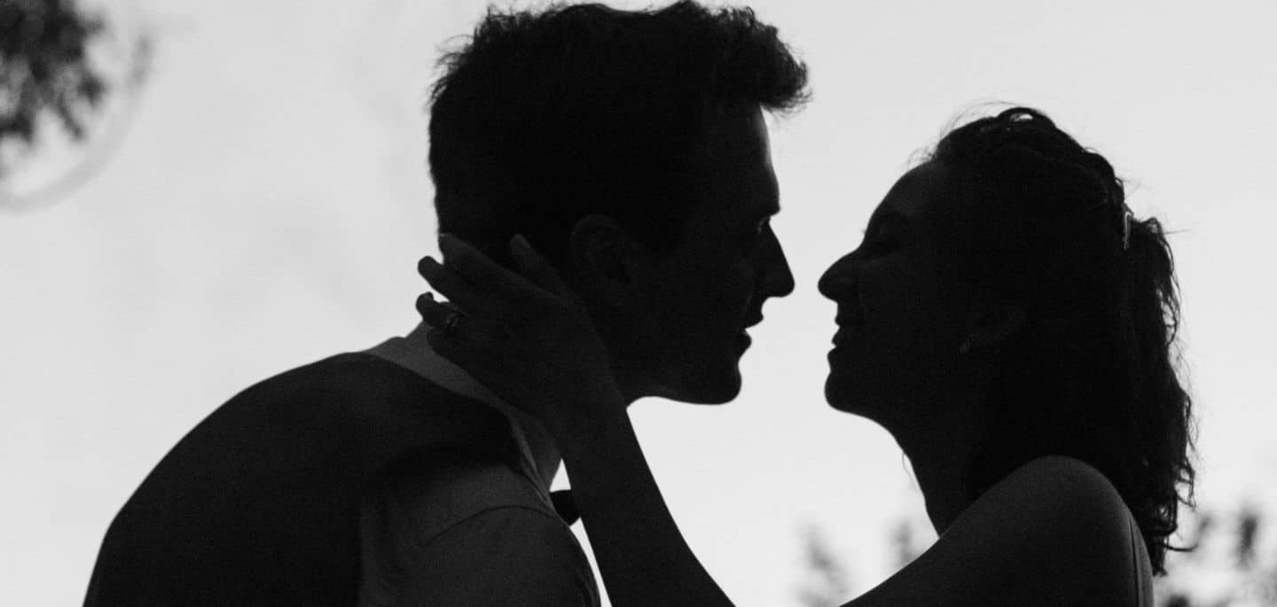 Cette image présente un couple marié qui s'apprêtent à s'embrasser